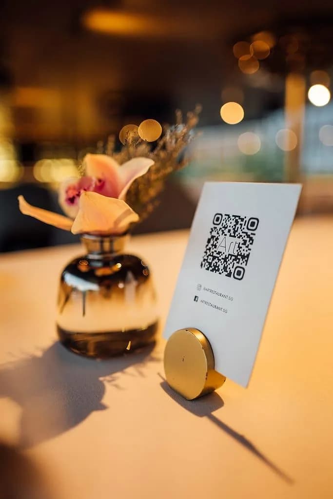 Hotel lounge table with brass stand holding artistic QR card